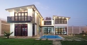 a large white house with a pool in front of it at Vacation Home - Villa Konecta in Santiago de Cao