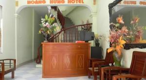 a room with a staircase and a mirror and flowers at Hoang Hung Hotel in Hanoi