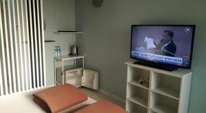 a living room with a flat screen tv on a stand at Daddy's home Huahin in Hua Hin