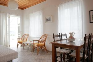 a dining room with a table and chairs in a room at Kiki's Houses Vlichos in Hydra