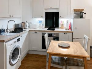 une cuisine avec une machine à laver et une table dans l'établissement Little Barn - Cottage, à Holsworthy 20 autres photos