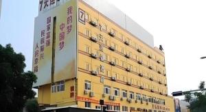 a yellow building with writing on the side of it at 7 Days Inn Zhongshan Southern District Daxin Xinduhui in Huancheng