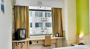 a hotel room with a television and a window at 7 Days Inn Luoyang Wangcheng Park Metro Station in Luoyang