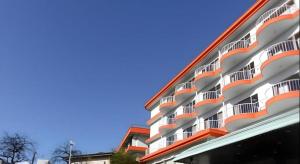 ein großes Apartmenthaus in Rot und Weiß in der Unterkunft Yugawara Onsen Hotel Akane in Mongawa