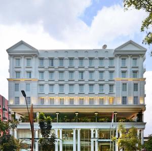 a large white building with a lot of windows at Grand Savero Hotel Bogor in Bogor