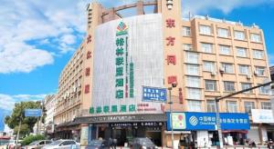 a large building with a sign on the side of it at GreenTree Alliance Ningbo Cixi Guanghaiwei Industrial Park East Area Hotel in Ningbo
