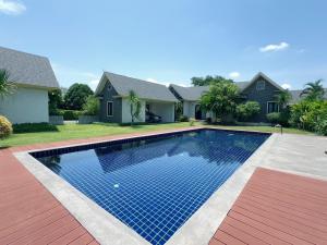 a swimming pool in front of a house at Ban 5 Rai Pool Villa in Chiang Mai
