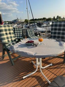 MaasbommelHausboot KOMET Luxus und Natur pur max 5 Pers的船上甲板上摆放着一碗水果的桌子