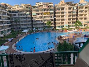 a large swimming pool in front of some apartment buildings at ELzohor Resort in Alexandria