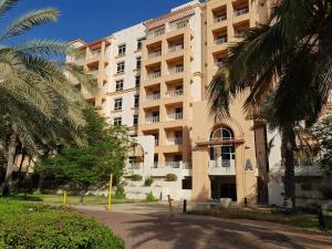 a large building with palm trees in front of it at شقه ليالي المارينا اطلاله بحريه عوائل in King Abdullah Economic City