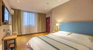 a bedroom with a large bed and a large window at JTOUR Inn Wuhan Wusheng Road Metro CapitaLand Plaza in Wuhan