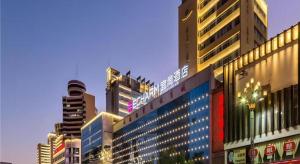 eine Gruppe von Gebäuden in einer Stadt bei Nacht in der Unterkunft Echarm Hotel Kunming Railway Station Huancheng South Road Metro Station in Kunming