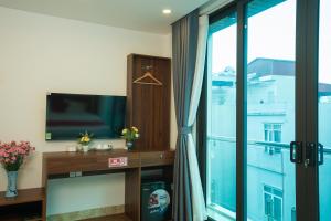 a living room with a tv and a window at Atypik Vietnam House in Hanoi