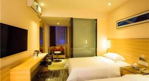 a hotel room with two beds and a desk at JTOUR Inn Wuzhou Arcade City Sanzongfu in Wuzhou +43 photos