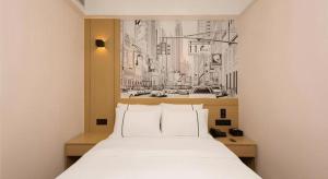 a bedroom with a white bed with a picture of a city at City Comfort Inn Guangzhou Southern Hospital Tonghe Metro Station in Guangzhou +194 photos