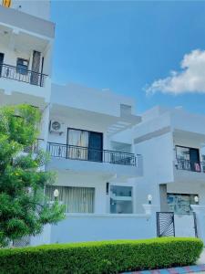 un condominio bianco con balconi e un albero di Rudra inn Peaceful 3BHK Villa near All Mandirs Vrindavan a Vrindāvan