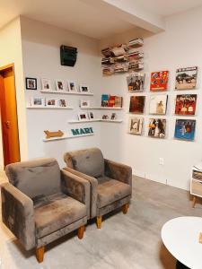 a room with two chairs and a wall with pictures at Casa Lajeiro in Serra de São Bento