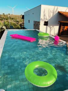 a pool with green and pink frisbees in the water at Casa Lajeiro in Serra de São Bento