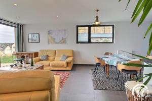 a living room with a table and a couch at Les belles vues d'erquy in Erquy