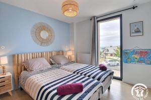a bedroom with a bed and a large window at Les belles vues d'erquy in Erquy
