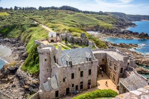 an old castle on a cliff next to the ocean at Les belles vues d'erquy in Erquy