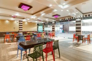 a dining room with tables and colorful chairs at Hotel O Mini Punjab Hills in Jamshedpur +29 photos