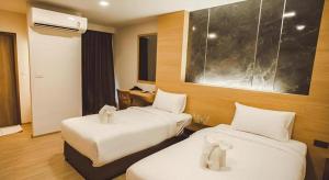 Una habitación de hotel con dos camas y un escritorio. en B2 Amata Nakorn Premier Hotel, en Ban Chak Samo 77 fotos más