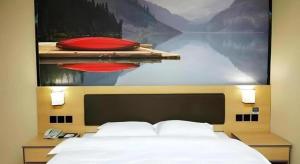 une chambre avec un tableau au-dessus d'un lit dans l'établissement Thank Inn Hotel Sichuan Nanchong Gaoping District Longmen, à Gaoping