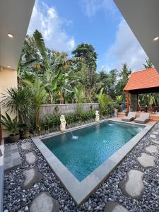 a swimming pool in the middle of a yard at Pondok Lekad D'ubud Private Pool in Ubud