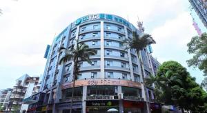 a tall building with palm trees in front of it at City Comfort Inn Nanning Minzhu Road Guangxi Dianwang in Nanning