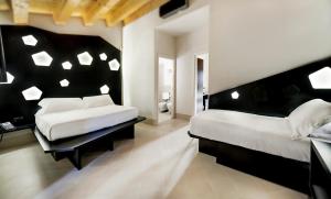 a bedroom with two beds with white sheets and white pillows at Addauro Resort in Siracusa