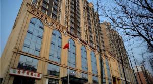 un grand bâtiment avec un drapeau rouge devant lui dans l'établissement Xana Hotelle Rizhao Lanshan District Government, à Lanshantou