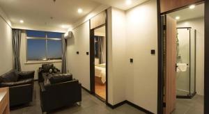 a living room with a couch and a chair and a window at GreenTree Inn Express Shandong Zaozhuang Shizhong District Huashan Road Ginza in Zaozhuang