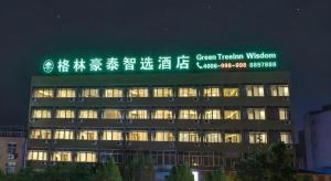 a building with a green sign on the top of it at GreenTree Inn Express Shandong Zaozhuang Shizhong District Huashan Road Ginza in Zaozhuang