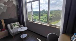 une pièce avec une chaise, une table et une fenêtre dans l'établissement Thank Inn Hotel Guangxi Qinzhou Lingshan Renhe, à Lingshan 54 autres photos