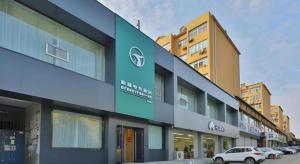 a building with cars parked in front of it at GreenTree Esports Hotel Qingdao Licang District Wanda in Qingdao