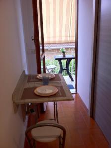 uma mesa com um prato ao lado de uma janela em House Via Manzoni em Terracina