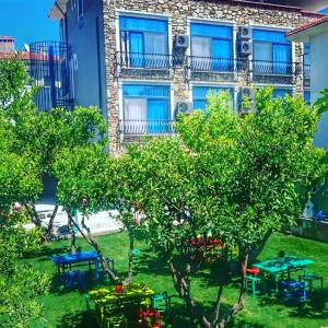 een gebouw met blauwe ramen en tafels in een tuin bij Pirlanta Butik Hotel in Çeşme