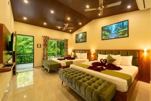 ein Schlafzimmer mit zwei Betten und ein Wohnzimmer in der Unterkunft New Wind Stay in Dandeli