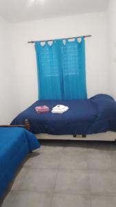 a bedroom with a bed with a blue curtain at Departamento CR in Alta Gracia