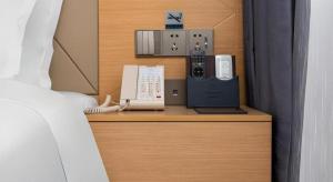 ein Schreibtisch mit einem Telefon und anderen elektronischen Geräten darauf in der Unterkunft Borrman Hotel Guangzhou Shisanhang Ximenkou Metro Station in Guangzhou