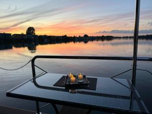 MaasbommelHausboot KOMET Luxus und Natur pur max 5 Pers的船头的桌子上放着两根蜡烛