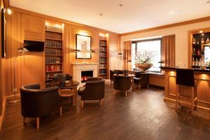 a room with a bar with chairs and a fireplace at TOWNHOUSE Hotel in Frankfurt/Main