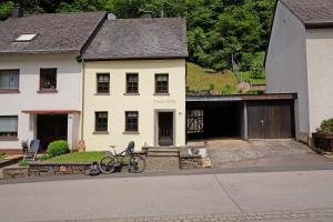 ein Fahrrad, das vor einem weißen Haus geparkt ist in der Unterkunft Haus Anna in Veldenz