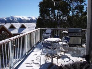 a balcony with chairs and a table in the snow at Sun Valley Apartment 7 in Falls Creek