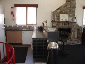 a kitchen with a stone fireplace and a counter top at Sun Valley Apartment 7 in Falls Creek