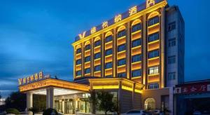 a hotel with a lit up building in front at Vienna Hotel Beijing Fangshan District Guangyangcheng Metro Station in Wangzhuang