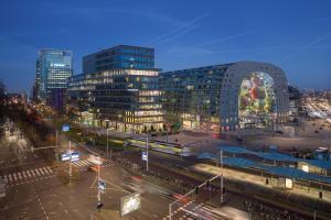 a city with buildings and a street at night at Savoy Hotel Rotterdam in Rotterdam