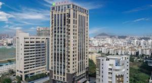 un grand bâtiment avec un panneau en haut dans l'établissement Vienna Hotel Fujian Fuqing Wanda Plaza, à Fuqing