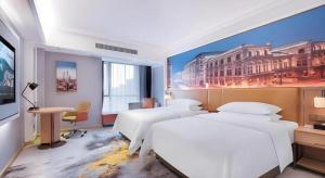 a bedroom with two beds and a painting on the wall at Vienna Hotel Anhui Bengbu Free Trade Zone in Bengbu